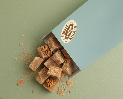 Box of fudge with vEdward's fudge kitchen logo on a two-tone background